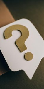 Artistic paper craft of a question mark symbol on a textured green surface.